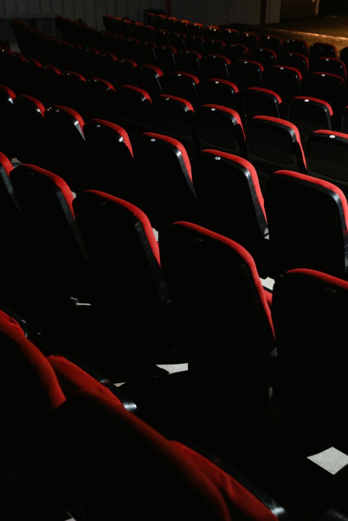 pexels-photo-7991182-7991182 An empty theater with red seats, dim lighting captures a tranquil ambiance.